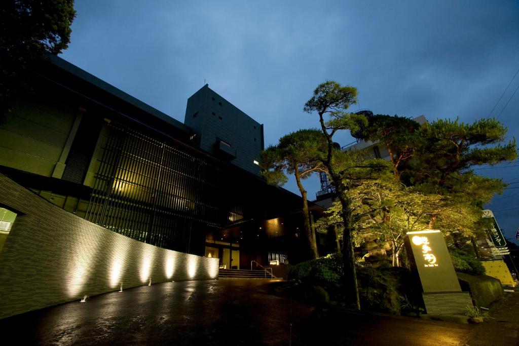 un bâtiment avec des lumières sur le côté dans l'établissement Ito Yukitei, à Itō