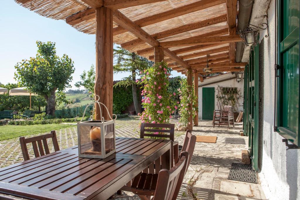 une table en bois avec des chaises sous une pergola en bois dans l'établissement Casa S.Paolo, à Rimini