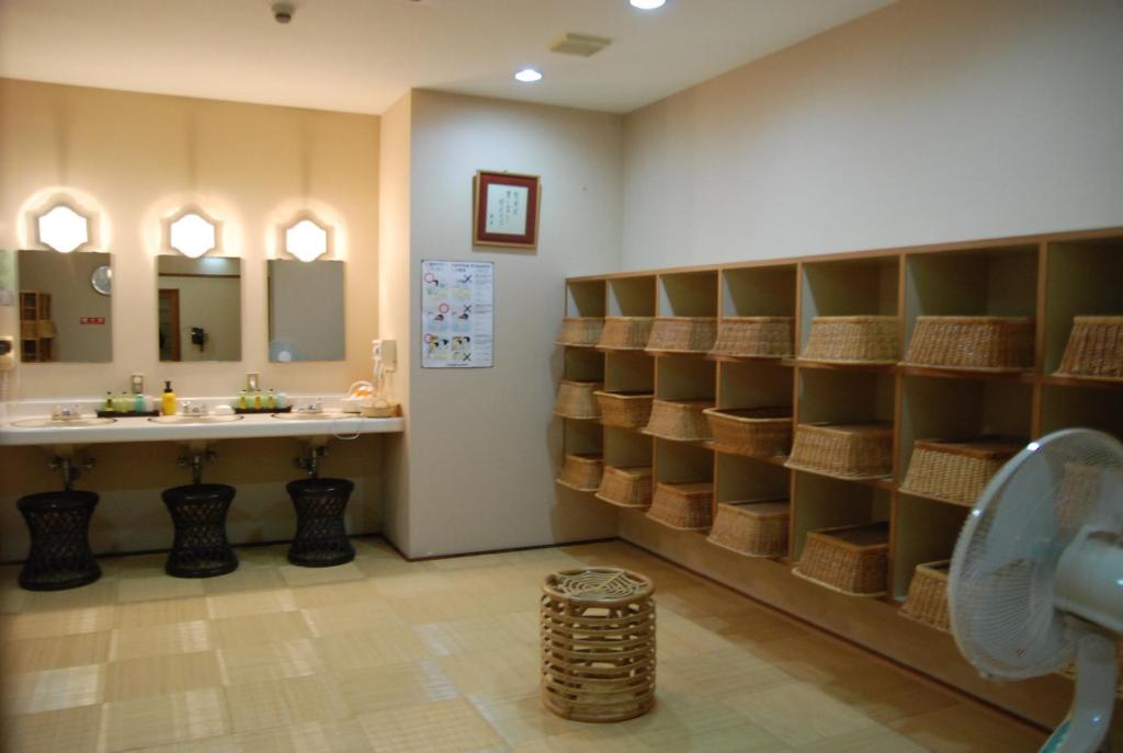 La salle de bains est pourvue d'un lavabo et d'un comptoir avec des étagères. dans l'établissement Shiunso, à Hakone