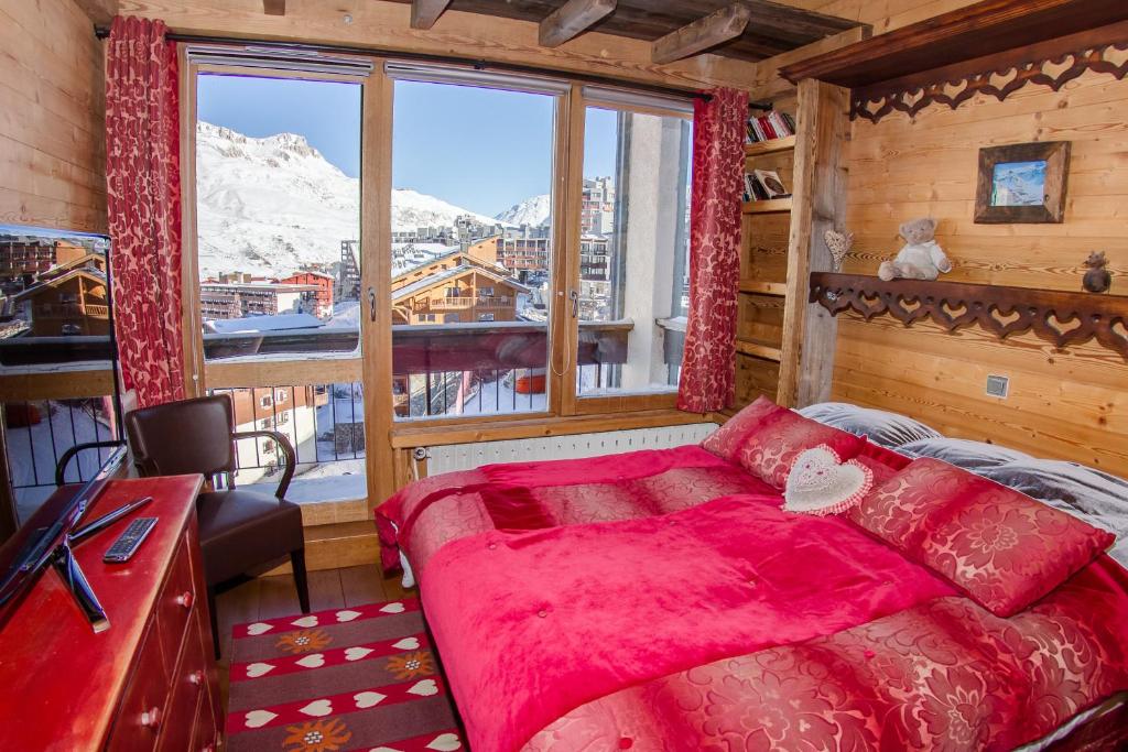 une chambre avec un lit et une grande fenêtre dans l'établissement Tignes duplex luxe parking 6-8 p, à Tignes