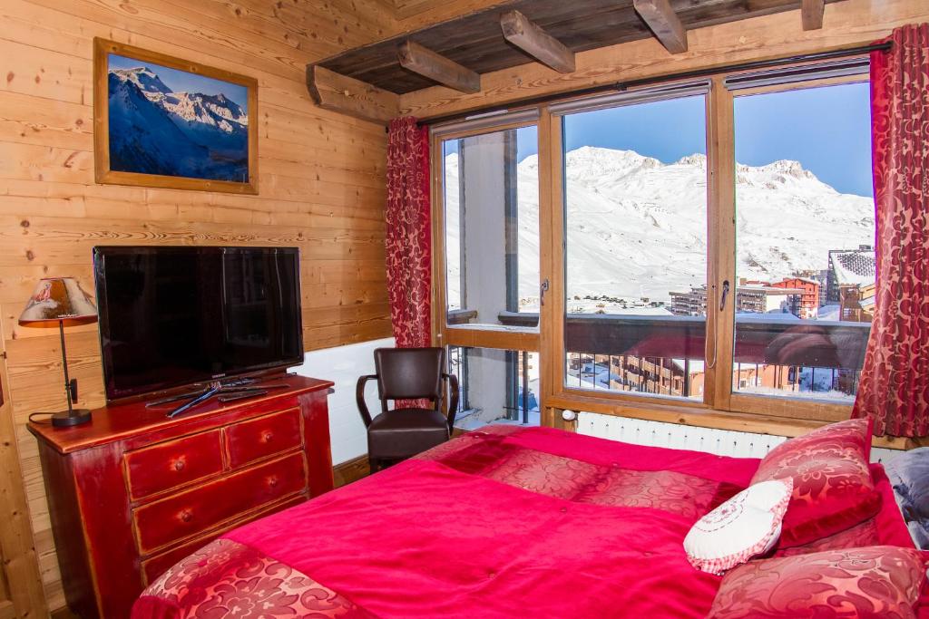 - une chambre avec un lit et une fenêtre avec une montagne enneigée dans l'établissement Tignes duplex luxe parking 6-8 p, à Tignes