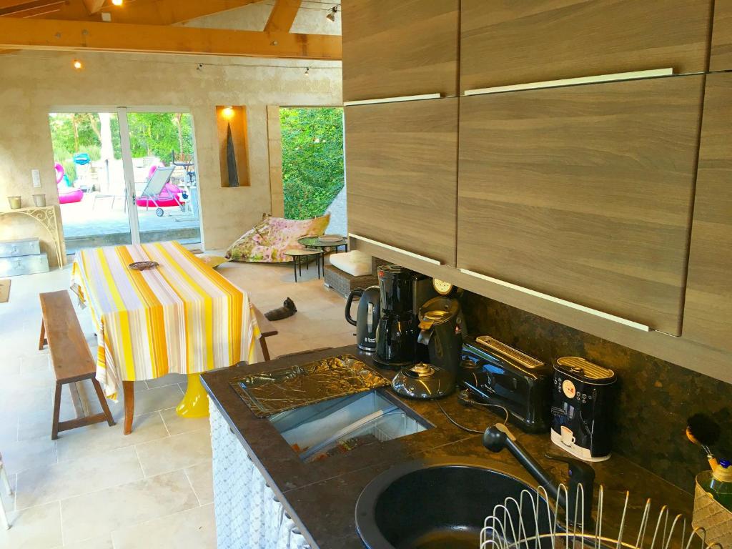 - une cuisine avec un évier et une table dans une chambre dans l'établissement Gîtes Sibémol, à Simeyrols