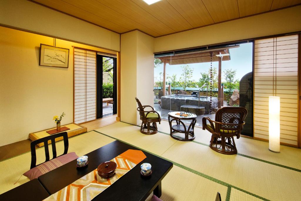 un salon avec une table et des chaises dans l'établissement Yunaginoyu Hotel Hanajyukai, à Takamatsu