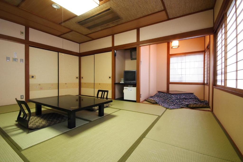 une pièce avec une table et des chaises dans l'établissement Gyokusenkaku, à Nagato