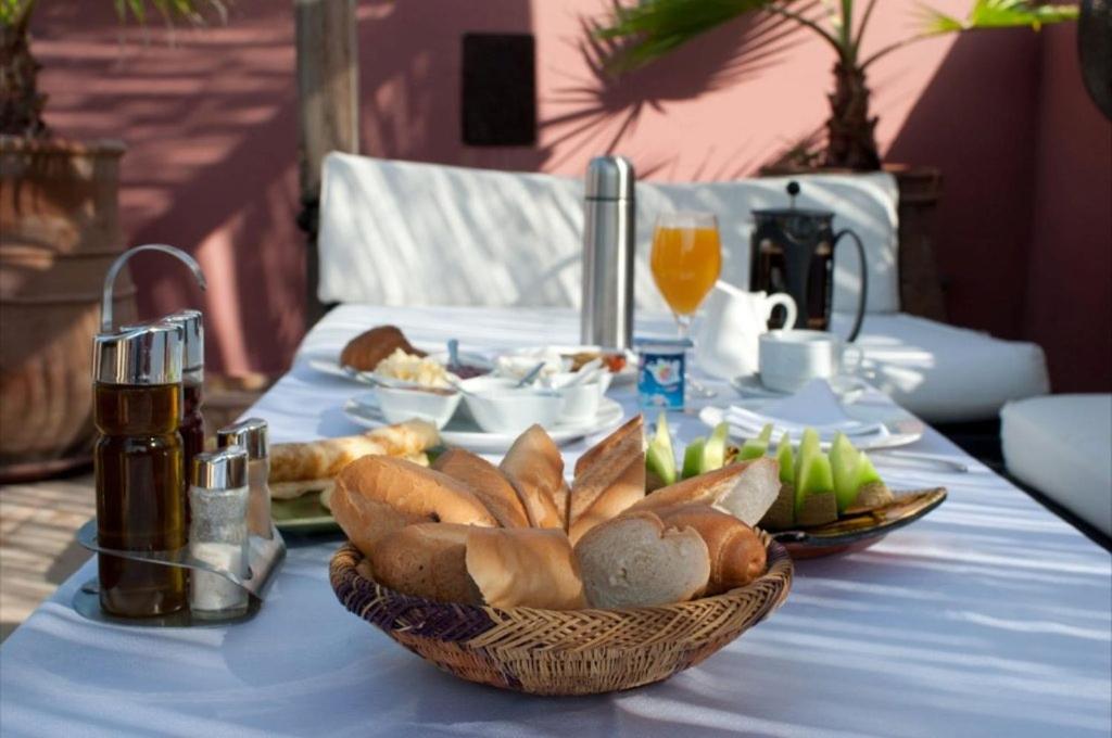 une table avec un tissu de table bleu et un panier de pain dans l'établissement Dar Rocmarra, à Marrakech