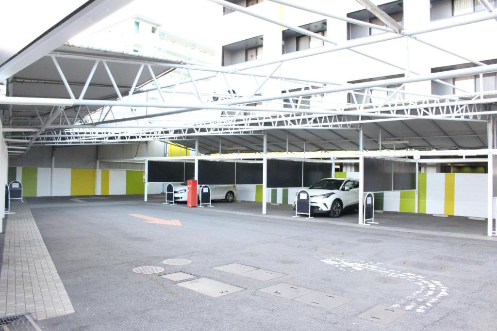 un parking avec une voiture garée à l'intérieur d'un bâtiment dans l'établissement Pal Annex Furugou, à Ōita