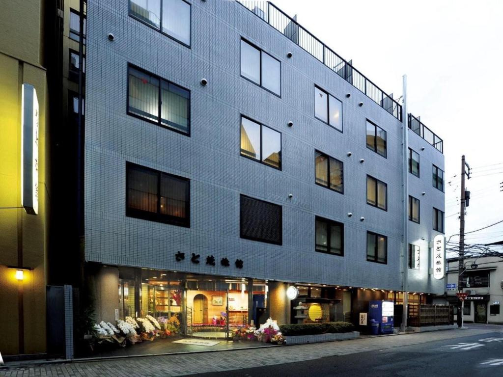 un grand bâtiment au bord d'une rue dans l'établissement Satomo Ryokan, à Kyoto