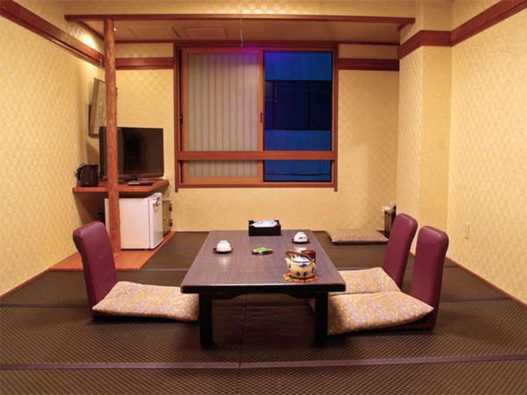 un salon avec une table et des chaises violettes dans l'établissement Satomo Ryokan, à Kyoto