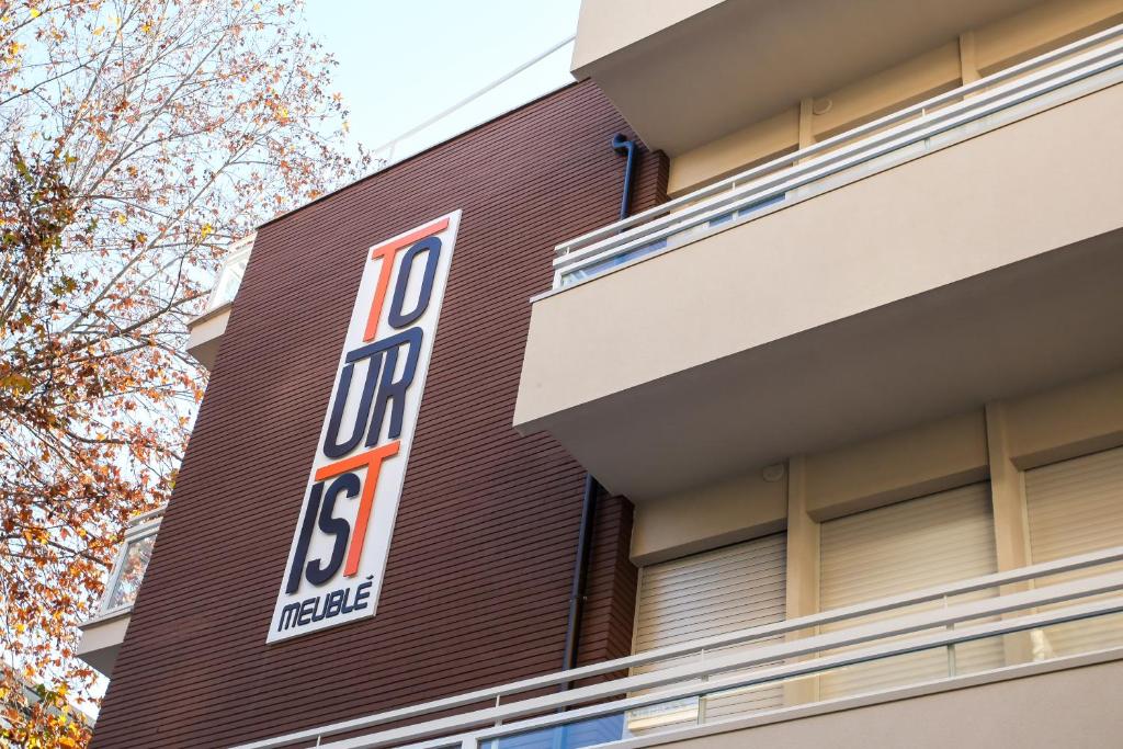 un panneau sur le côté d'un bâtiment dans l'établissement Hotel Tourist Meuble, à Rimini 19 autres photos