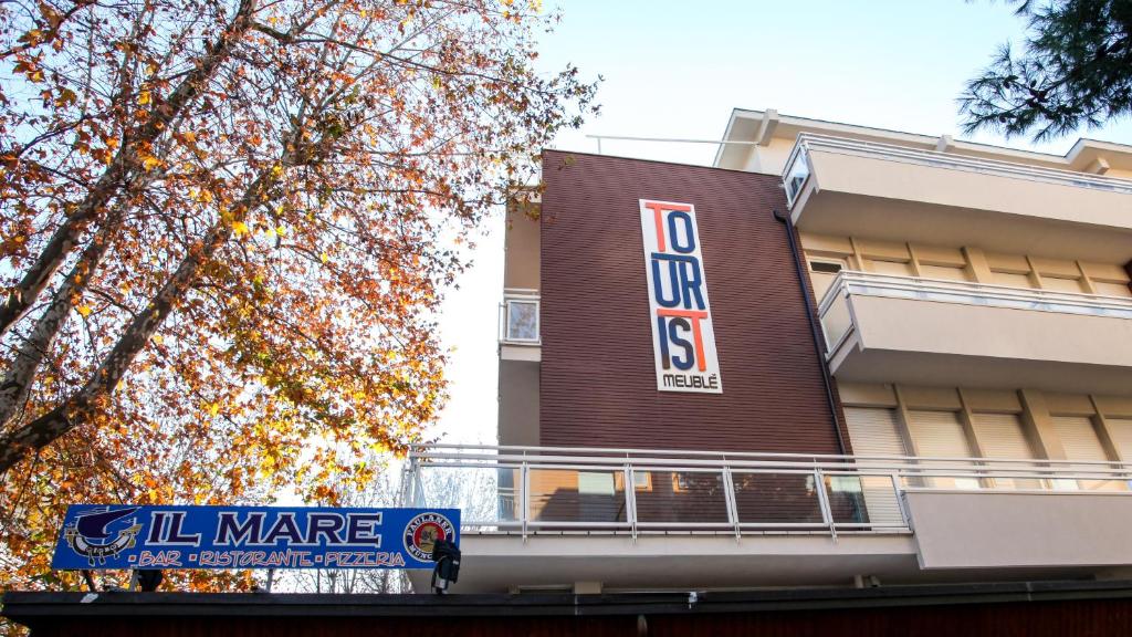un bâtiment avec une enseigne sur le côté dans l'établissement Hotel Tourist Meuble, à Rimini