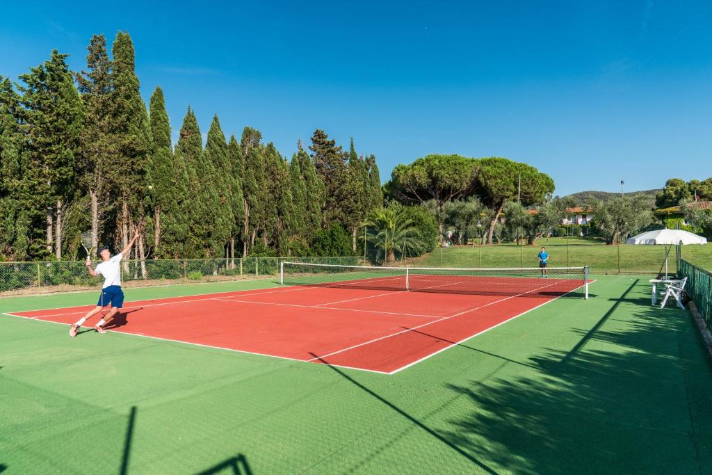 une personne jouant au tennis sur un court de tennis dans l'établissement Hotel Fabricia, à Portoferraio