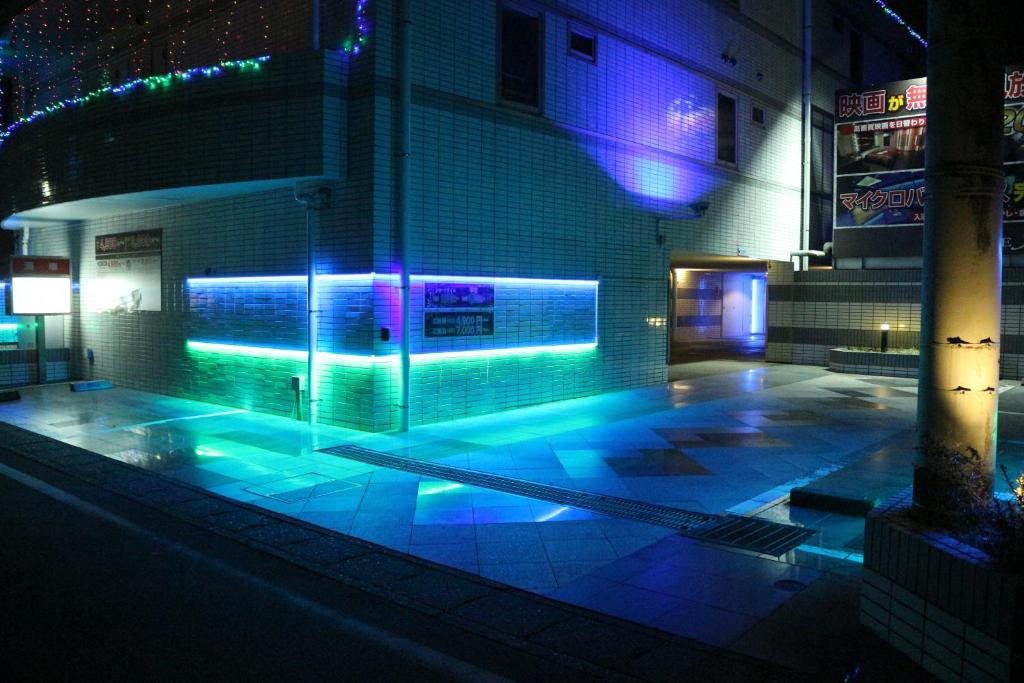 - un bâtiment doté d'une piscine avec des lumières bleues et violettes dans l'établissement Terrace M Yokota Bace ( Adult Only ), à Hakonegasaki