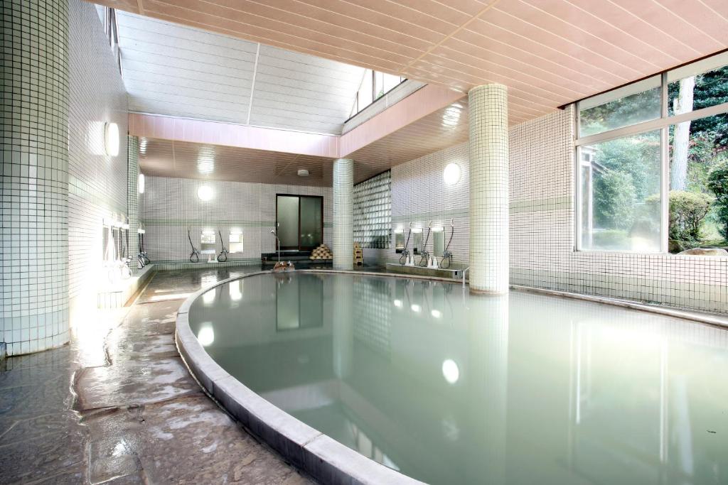 - une grande piscine avec une baignoire dans une maison dans l'établissement Unzen Sky Hotel, à Unzen
