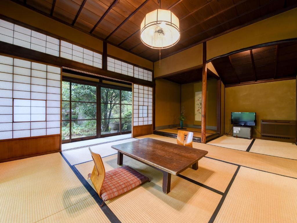 un salon avec une table et des chaises en bois dans l'établissement Nagataki, à Nakatsugawa 37 autres photos