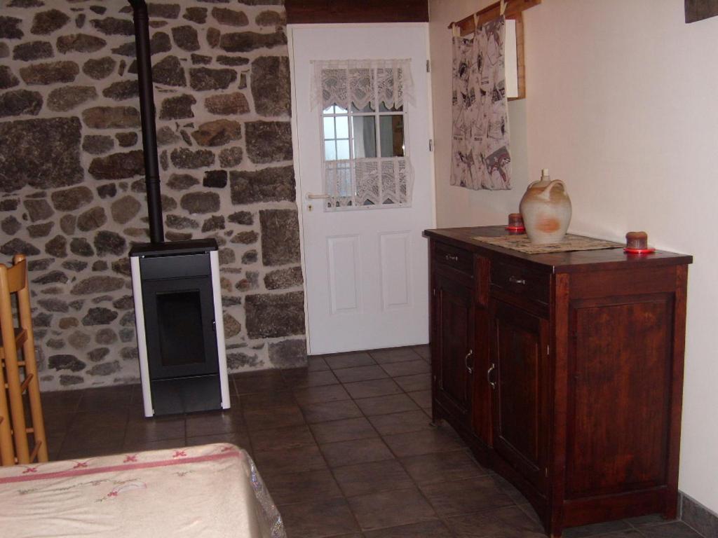 Cette chambre est dotée d'une cheminée et d'un mur en pierre. dans l'établissement chez Angèle, à Le Mont-Dore