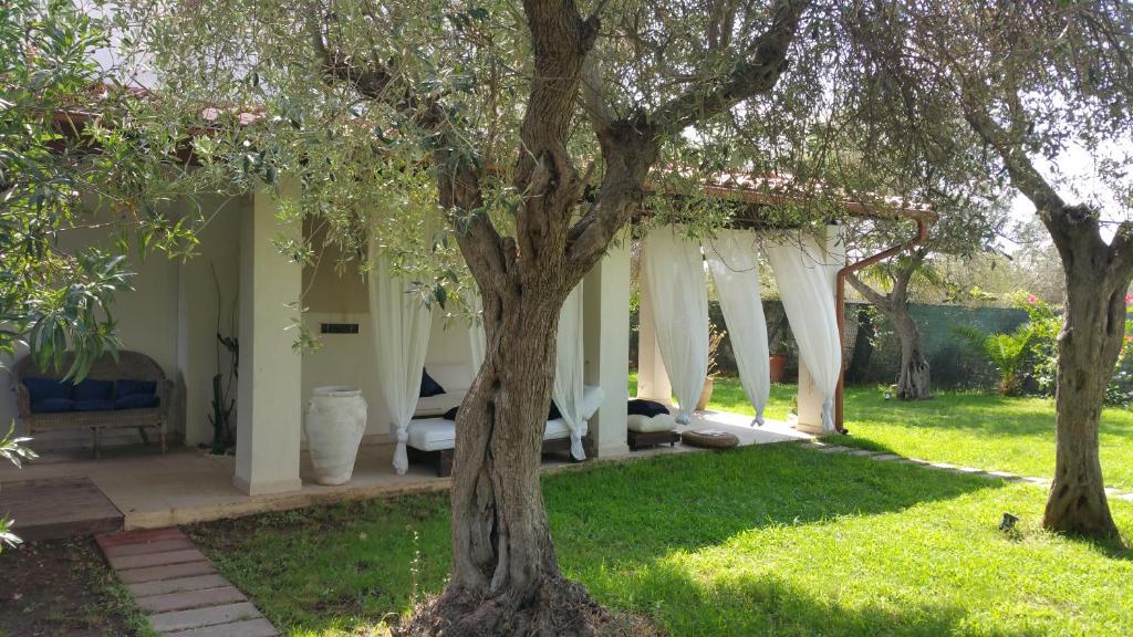 une chambre avec un lit et des arbres dans une cour dans l'établissement Villa Ines con piscina sud Sardegna, à Capoterra