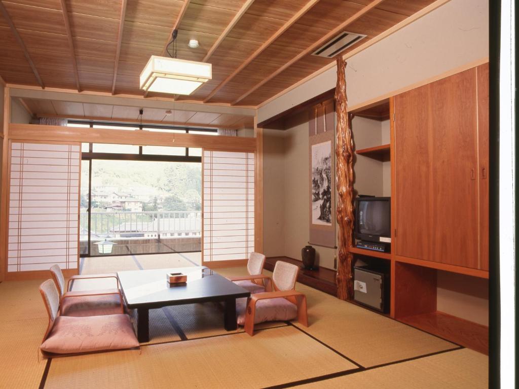 un salon avec une table et des chaises dans l'établissement Yuttarino-Sato Inaka, à Achi