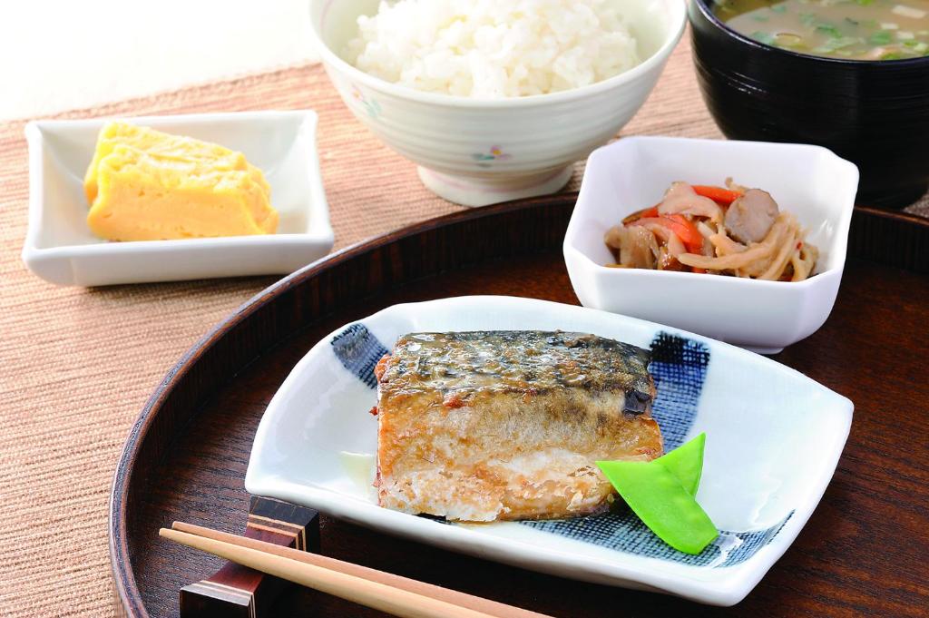 une table avec une plaque de nourriture à base de riz et de baguettes dans l'établissement HOTEL Rplus日高, à Hidaka