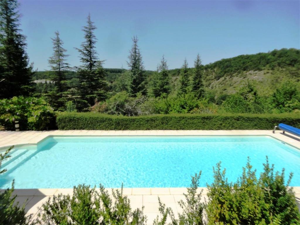 une grande piscine avec une montagne en arrière-plan dans l'établissement Gîtes Coeur de Lot, à Soucirac 37 autres photos