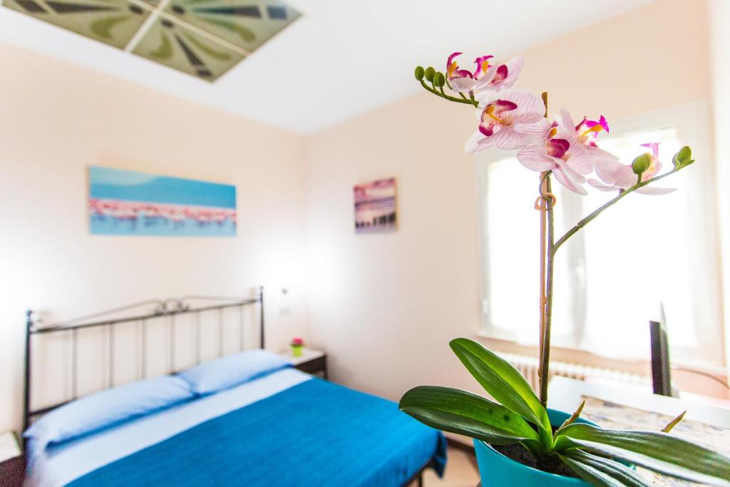 une chambre avec un lit bleu et une plante dans l'établissement Residence Kimba, à Rimini