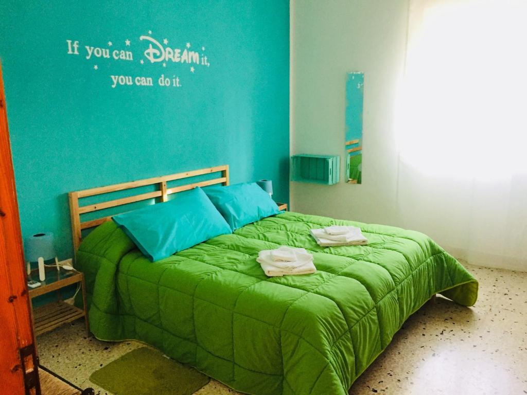 - une chambre avec un lit vert et des serviettes dans l'établissement I Colori degli Agrumi Holiday Home, à Floridia 33 autres photos
