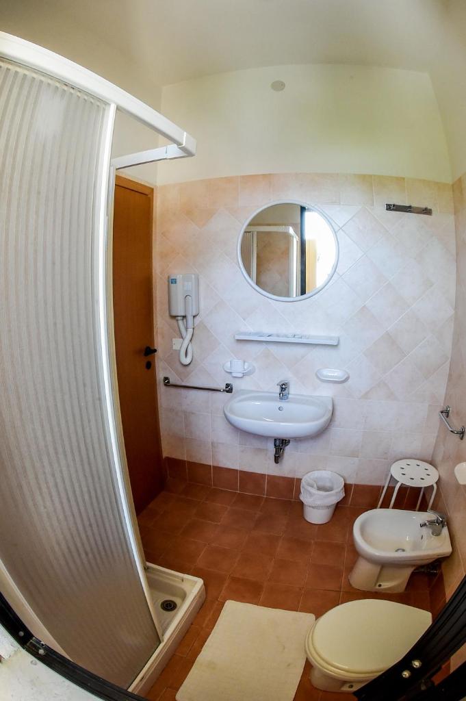 une salle de bain avec un lavabo, des toilettes et une douche dans l'établissement Hotel Riziana, à Cervia