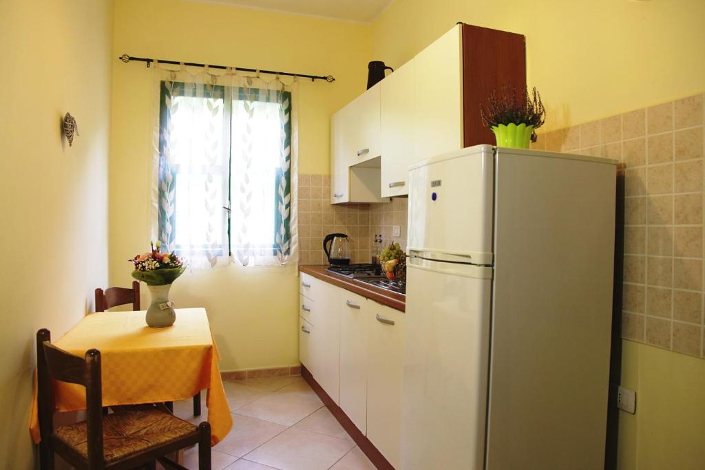 une cuisine avec un réfrigérateur blanc et une table dans l'établissement Residence Torre Saracena, à Villapiana