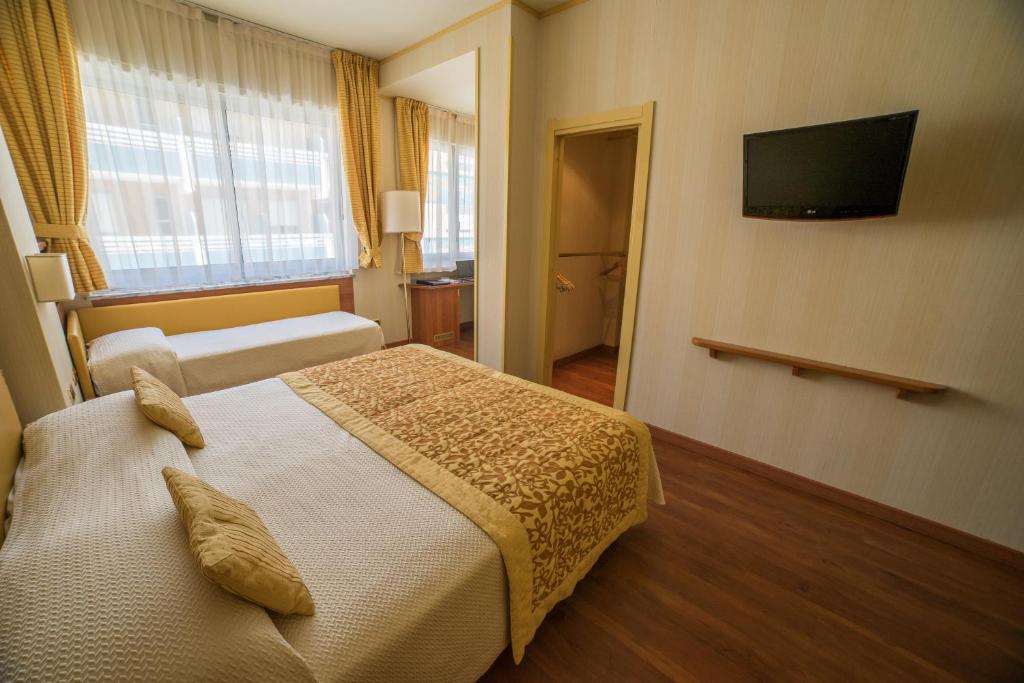 une chambre d'hôtel avec un lit et une télévision à écran plat dans l'établissement Hotel Garden Lido, à Loano