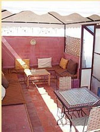 une chambre avec des tables, des chaises et un parasol dans l'établissement Dar Aida, à Rabat 27 autres photos
