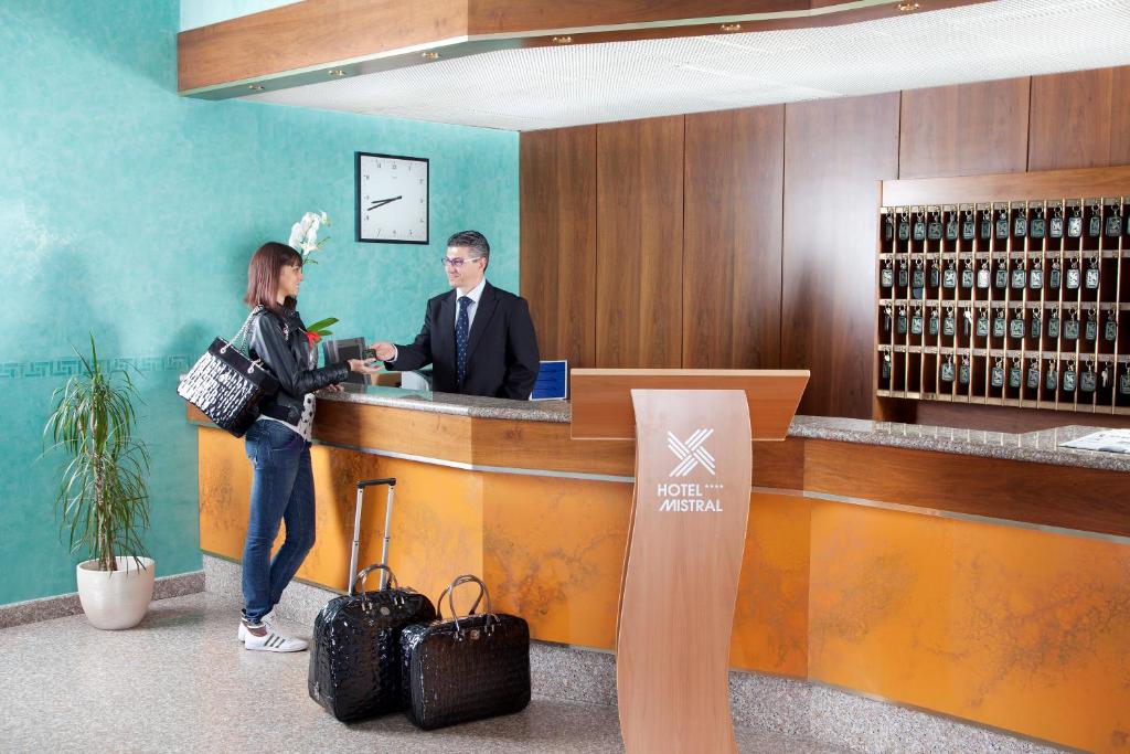 un homme et une femme debout à un bar dans l'établissement Hotel Mistral, à Termoli