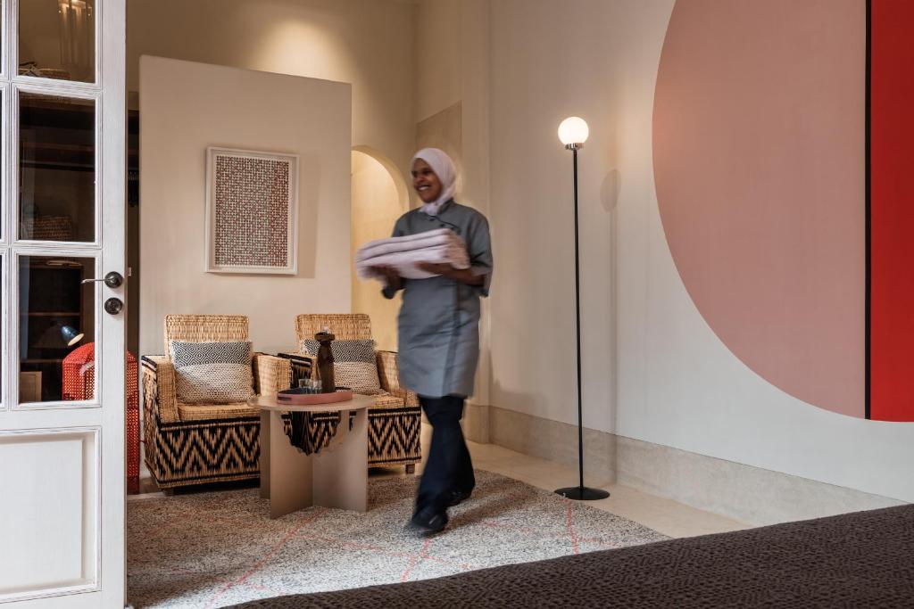 un homme marchant dans un couloir avec un sac de bagages dans l'établissement 72 Hotel & Spa, à Marrakech 37 autres photos