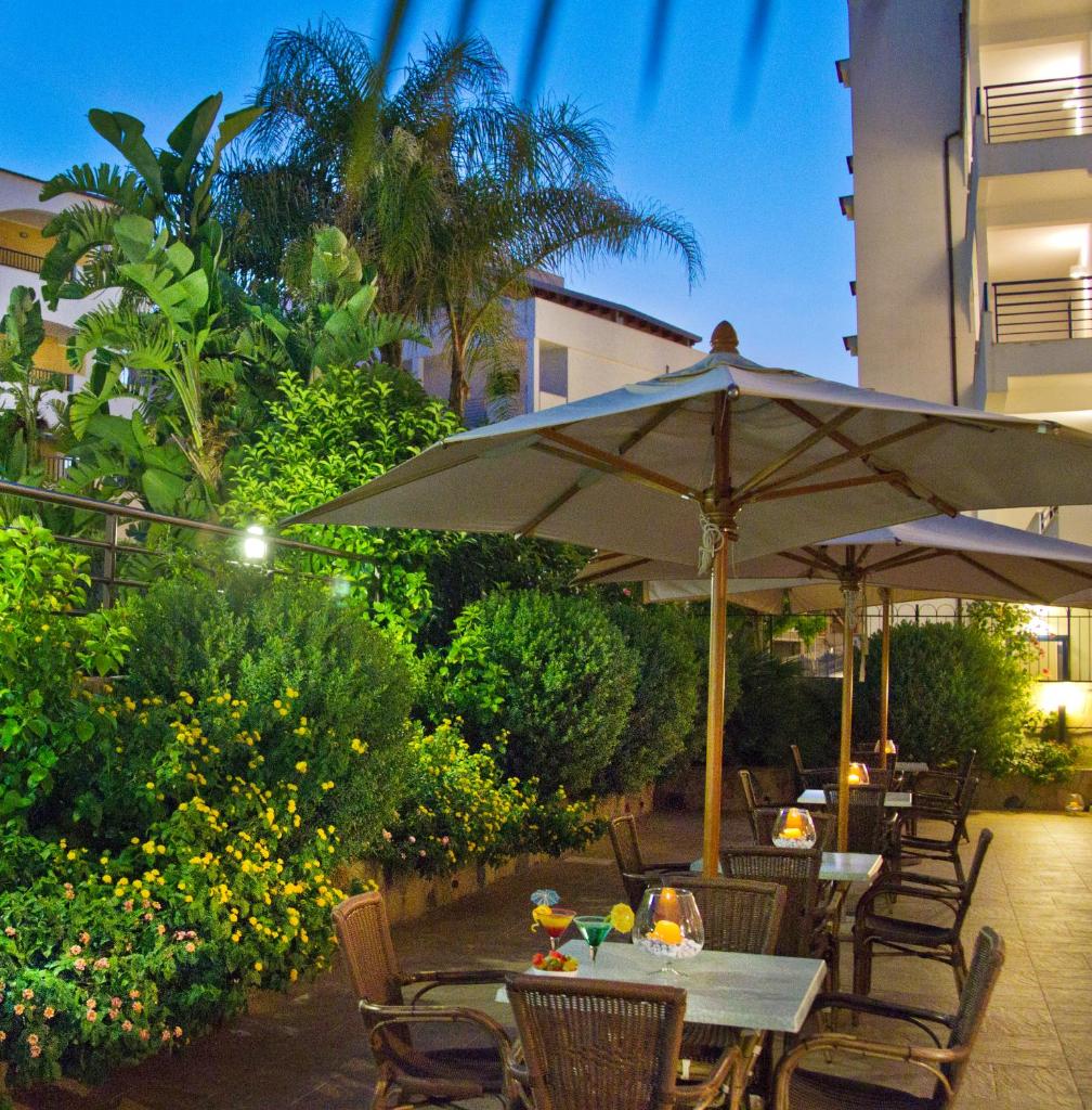 d'une terrasse avec des tables et des chaises et un parasol. dans l'établissement Forte Hotel, à Vieste