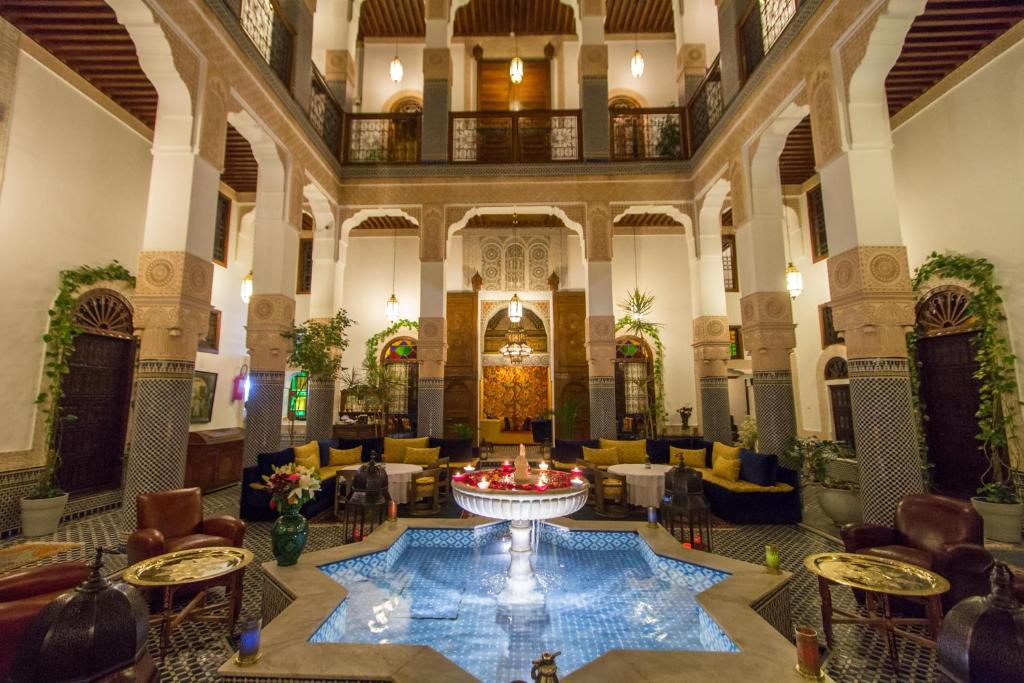 un hall avec une grande piscine au milieu dans l'établissement Riad Myra, à Fès