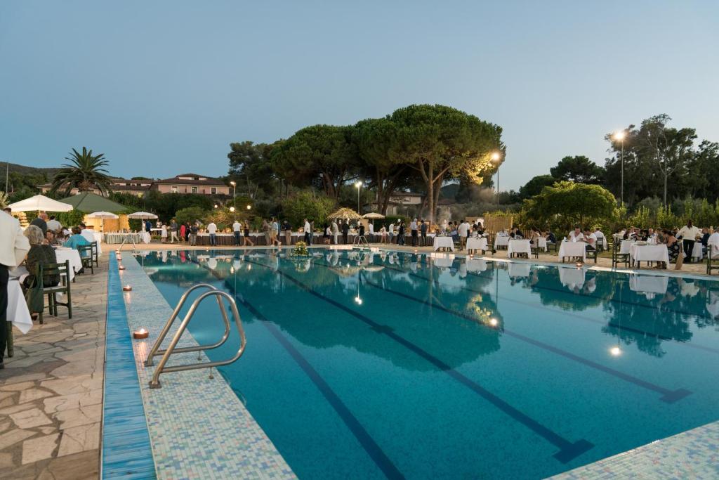 une piscine avec une foule de personnes assises autour de celle-ci dans l'établissement Hotel Fabricia, à Portoferraio