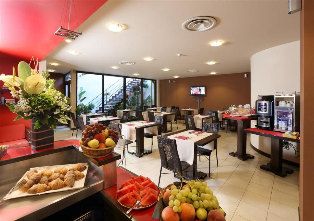 un restaurant avec des tables, des chaises et des fruits exposés dans l'établissement Hotel San Giovanni, à Giardini Naxos
