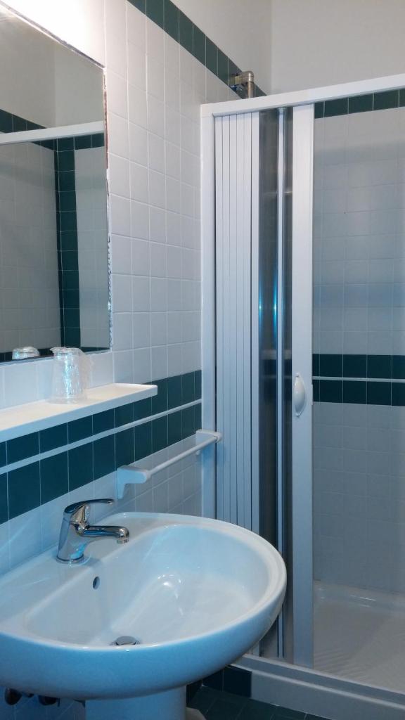 une salle de bain avec un lavabo et une douche dans l'établissement Villa Romana, à Lignano Sabbiadoro