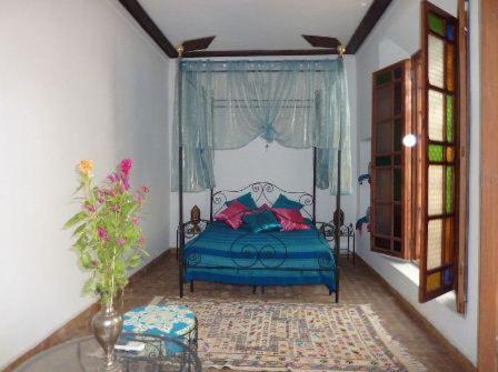 une chambre avec un lit bleu et une fenêtre dans l'établissement Dar Al Safadi, à Fès