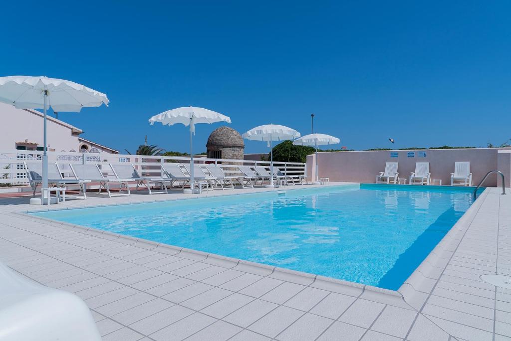 une grande piscine avec des chaises et des parasols blancs dans l'établissement Lido Azzurro, à Numana