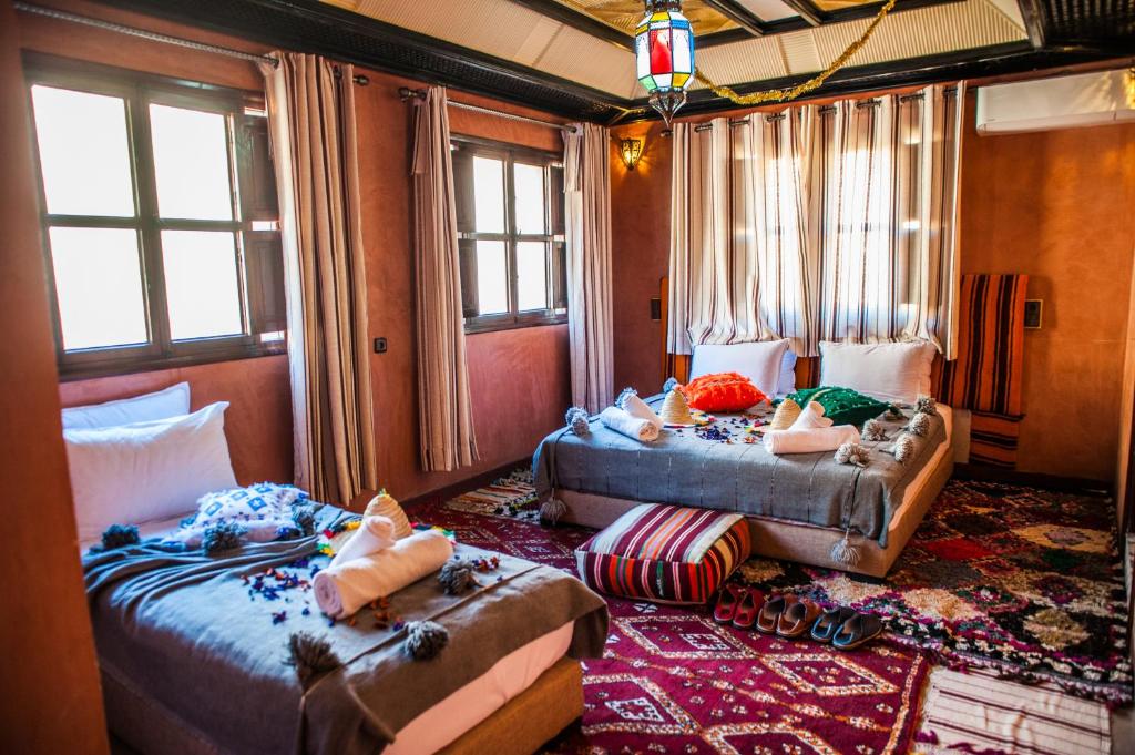une chambre avec deux lits et un canapé et des fenêtres dans l'établissement Toubkal Ecolodge, à Imlil