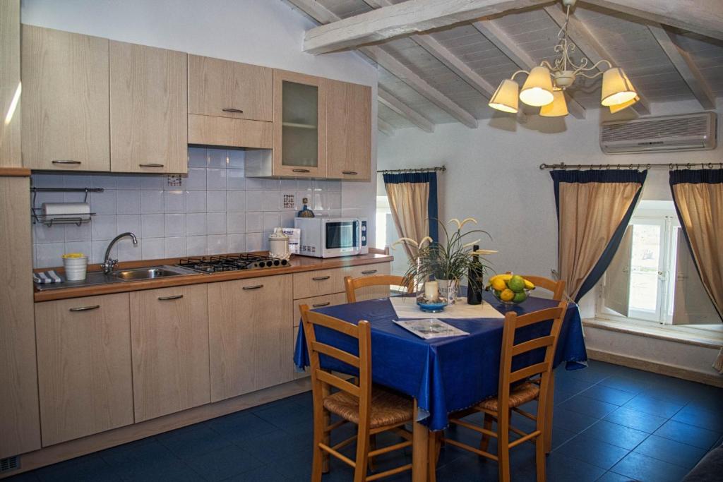 une cuisine avec une table et un chiffon bleu dans l'établissement Residence Villa Piani, à San Vincenzo
