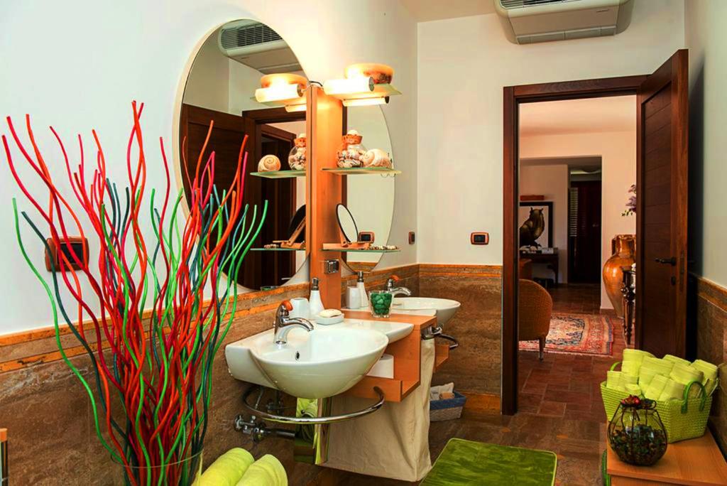 une salle de bain avec deux lavabos et un grand miroir dans l'établissement Villa Delle Lantane, à Mesagne