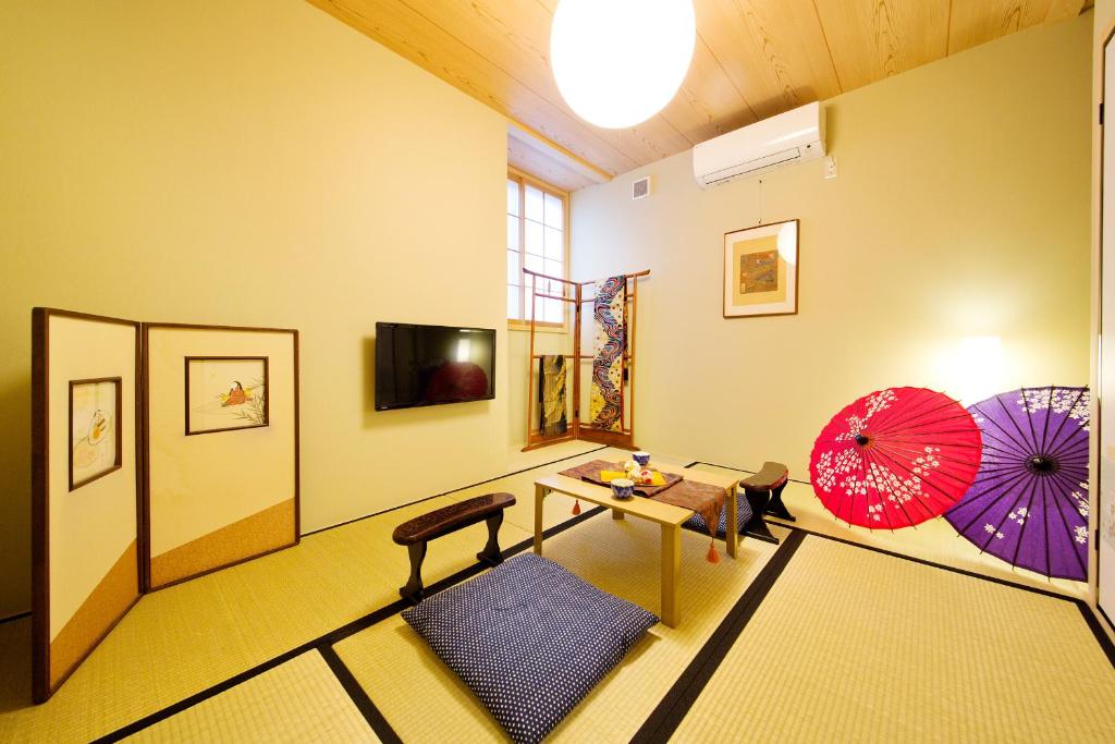 - un salon avec une table et deux parasols dans l'établissement add-Hostel Uji Cha-gan-ju-tei, à Uji
