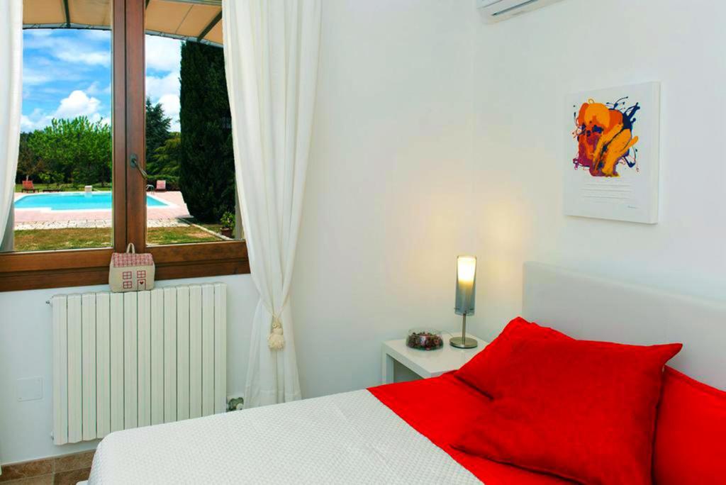 une chambre avec un lit avec des oreillers rouges et une fenêtre dans l'établissement Villa Delle Lantane, à Mesagne 34 autres photos