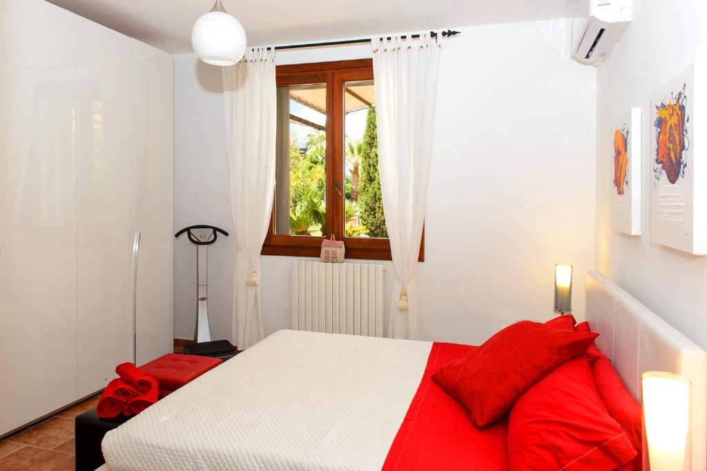 - une chambre avec un lit rouge et blanc et une fenêtre dans l'établissement Villa Delle Lantane, à Mesagne
