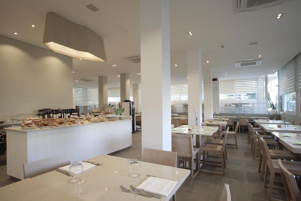 un restaurant avec des tables, des chaises et un comptoir dans l'établissement Hotel Gardenia, à Lido di Jesolo