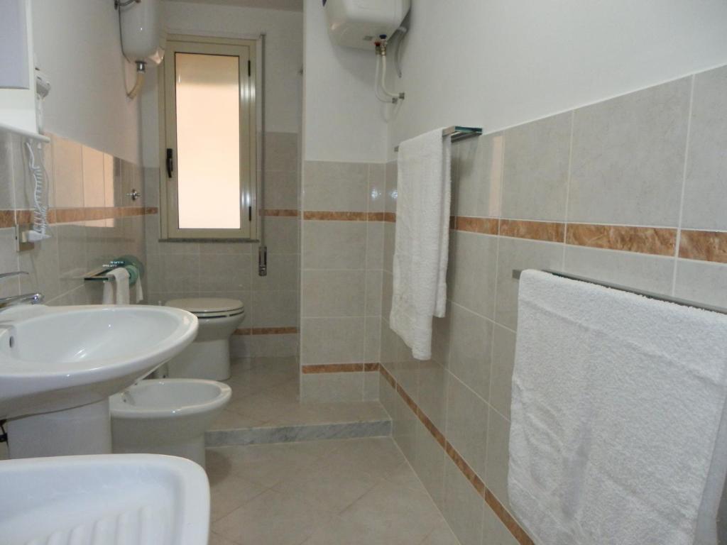 une salle de bain avec un lavabo et des toilettes dans l'établissement Residence Santa Barbara, à San Ferdinando
