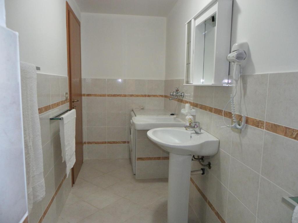 une salle de bain blanche avec un lavabo et un miroir dans l'établissement Residence Santa Barbara, à San Ferdinando 28 autres photos