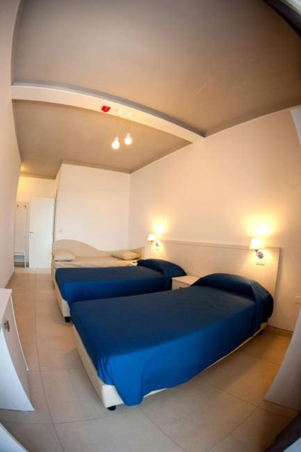 - 2 lits dans une chambre avec des draps bleus dans l'établissement Hotel La Terrazza, à Barletta