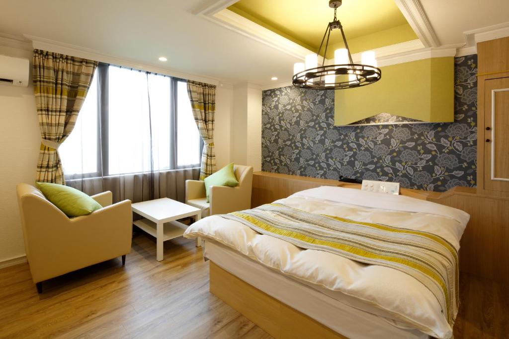 une chambre avec un lit, des chaises et un lustre dans l'établissement Hotel Sunset (Adult Only), à Choshi
