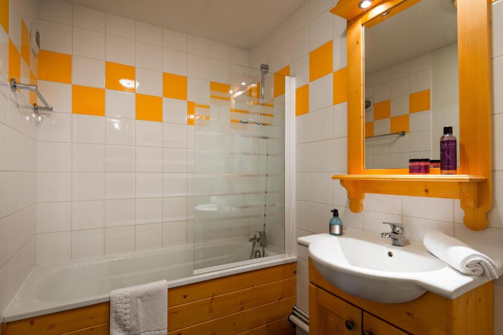 une salle de bain avec un lavabo et une baignoire dans l'établissement travelski home select - Résidence Les Chalets du Galibier, à Valloire